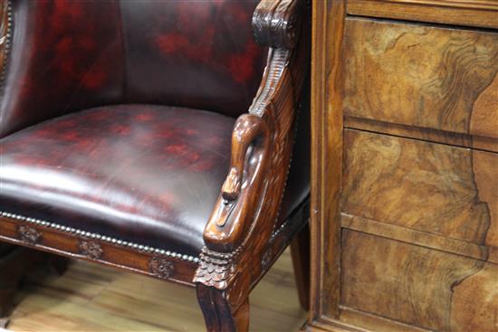 A pair of French Empire style carved mahogany and brass studded leather tub shaped armchairs,